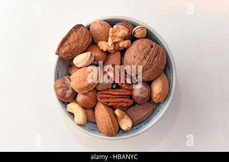 General view of mixed nuts in shell and and unselled, including hazelnuts, walnuts, almonds, Brazil nuts, pecan nuts, pistachio nuts, and cashew nuts. Stock Photo