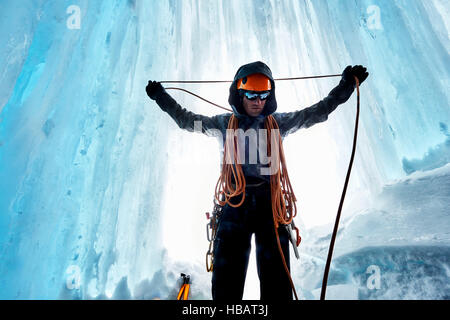 Man in ice cave preparing climbing rope, Saas Fee, Switzerland