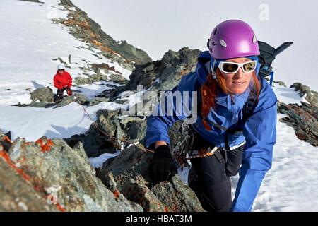 Mountaineer climbing up snow covered mountain, Saas Fee, Switzerland Stock Photo