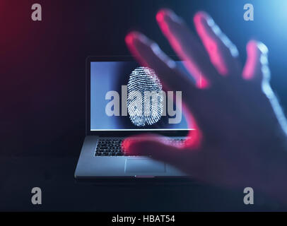 Computer Security, a finger print on a laptop illustrating a personnel password which is about to be hacked