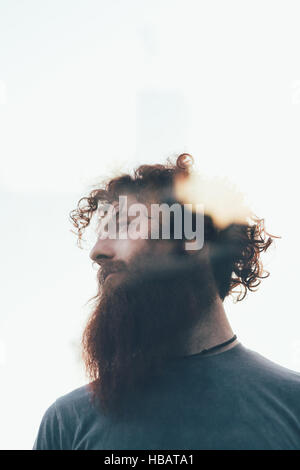 Low angle lens flare portrait of bearded hipster Stock Photo