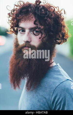 Portrait of curly haired, bearded young male hipster Stock Photo