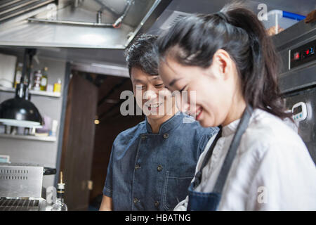 Chefs in commercial kitchen smiling Stock Photo
