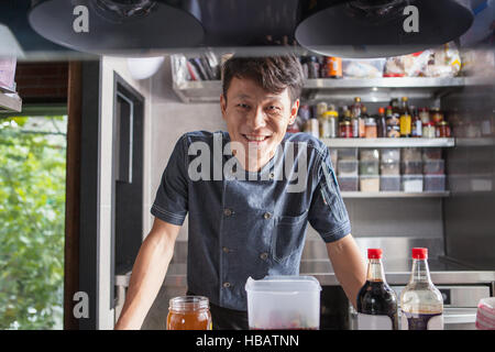 Portrait of chef in commercial kitchen looking at camera smiling Stock Photo