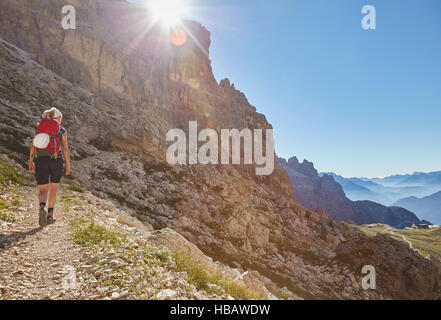 Rear view of female hiker hiking up Dolomites, Sexten, South Tyrol, Italy Stock Photo