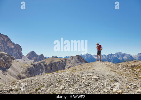 Rear view of female hiker looking out at Dolomites, Sexten, South Tyrol, Italy Stock Photo