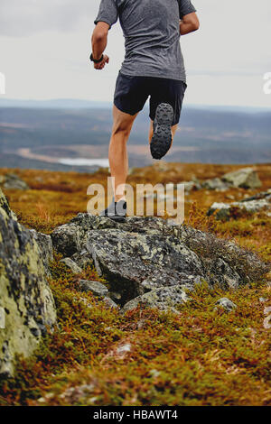 Man running on rocky cliff top, Keimiotunturi, Lapland, Finland Stock Photo