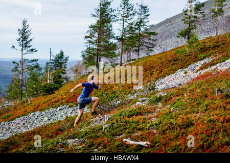 Man running up steep hill, Kesankitunturi, Lapland, Finland