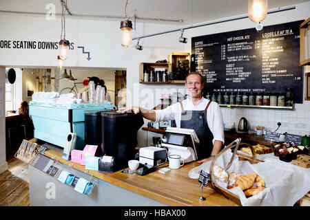 Portrait of male business owner behind counter of independent coffee shop Stock Photo