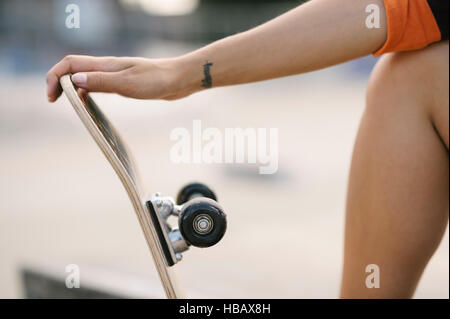Cropped shot of female skateboarder holding skateboard Stock Photo