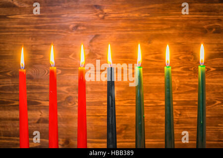 Kwanzaa festival concept with seven candles red, black and green on wooden background, close up Stock Photo