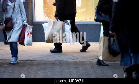 Black Friday and Christmas shopping in Brighton UK with shoppers carrying plastic and paper bags Stock Photo