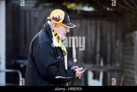 Male fan wearing a Sutton United Football Club rosette on his hat for FA Cup match Stock Photo