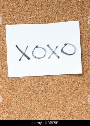 The series of a message on a piece of paper on the cork board, xoxo Stock Photo