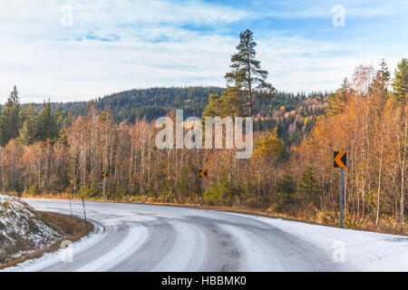 Empty rural Norwegian road covered with snow in autumn season Stock Photo