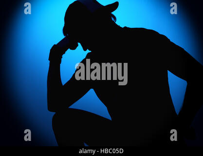 silhouette Rocker man posing on blue background Stock Photo
