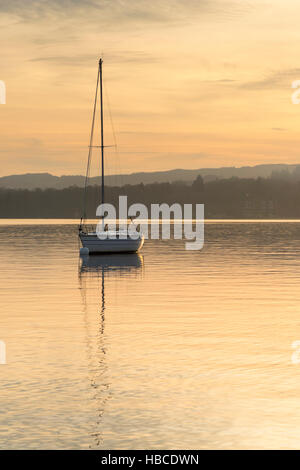 Waterhead on Lake Windermere Cumbria, UK. 5th Dec, 2016. After a cold sunny day, the sun sets over Lake Windermere silhouetting pleasure boats and moorings. After an overnight frost the weather has been crisp and sunny with similar weather forecast for tomorrow. Credit:  Julian Eales/Alamy Live News Stock Photo