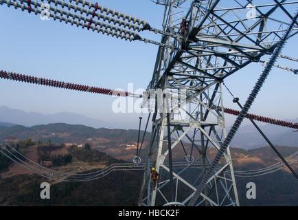 Chongqing. 6th Dec, 2016. Technicians inspect the tower of the ¡À800KV Ultra High Voltage (UHV) transmission line in Wushan County of southwest China's Chongqing, Dec. 6, 2016. The ¡À800KV UHV transmission line will run 2,383 meters from Jiuquan in northwest China's Gansu Province to Xiangtan in central China's Hunan Province. It's so far the longest transmission line of its kind in China. © Liu Chan/Xinhua/Alamy Live News Stock Photo