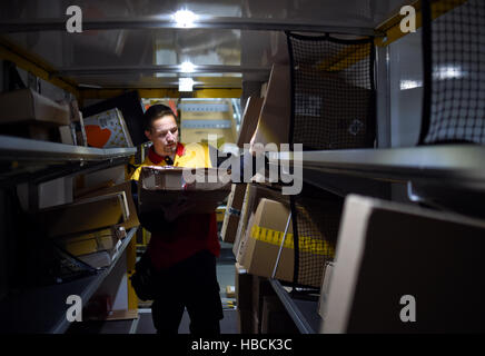 DHL worker Sven Steinkopf loads packages into a transporter in Berlin, Germany, 06 December 2016. The German company's busy Christmas period is already in full swing. Photo: Britta Pedersen/dpa-Zentralbild/dpa Stock Photo