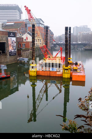 Bristol, UK. 6th December 2016. Work begins on installing the new footbridge at Finzels Reach, across the Bristol floating Harbour. each section is brought in by barge and lifted into place by crane, the finished Bridge will be S-shaped. Stock Photo