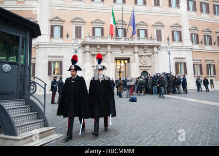 Rome, Italy. 6th December 2016. Two Italian Carabinieri walk past a flash mob lead by Matteo Salvini, head of Italy's Northern League, outside Palazzo Montecitorio in Rome, Italy. Credit:  Sara De Marco/Alamy Live News Stock Photo