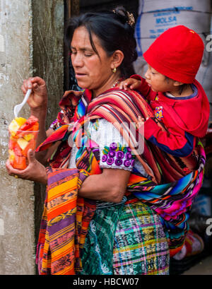 Guatemalan mother with here child buys fruits at the Chichicastenango Market. This native market is the most colorful in Central America