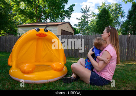 Caucasian Mother and Son play in and around their backyard inflatable pool Stock Photo