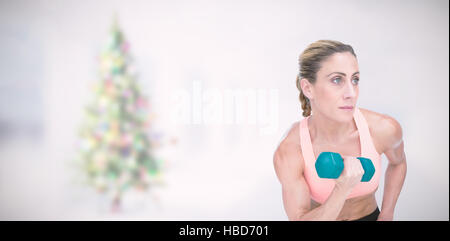 Composite image of strong woman doing bicep curl with blue dumbbell Stock Photo