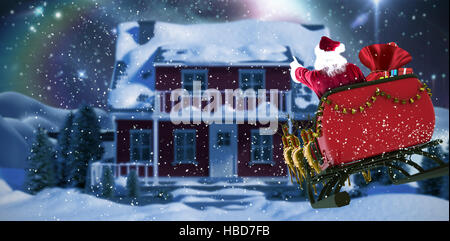 Composite image of santa claus riding on sled with gift box Stock Photo