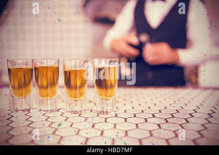 Composite image of glasses of whisky on bar counter Stock Photo