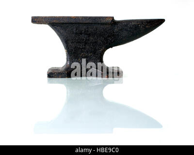 Blacksmith tools, an old anvil on a glass plate with white background. Stock Photo