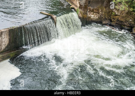 Water flows over a wall on the Deschutes River in Tumrwater, Washington. Stock Photo