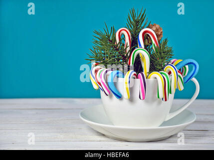 https://l450v.alamy.com/450v/hbefa6/christmas-candy-cane-and-pine-bouquet-in-white-cup-and-saucer-on-whitewashed-hbefa6.jpg