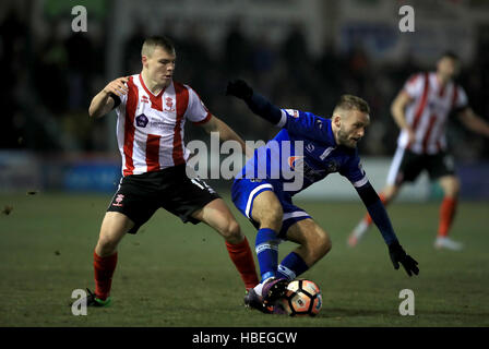 Oldham Athletic's Ryan McLaughlin (right) and Lincoln City's Harry Anderson battle for the ball during the Emirates FA Cup, Second Round match at Sincil Bank, Lincoln. Stock Photo