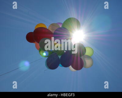 Bright air balloons against of sun shining on blue sky Stock Photo
