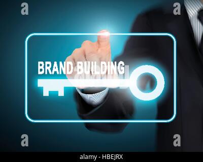 male hand pressing brand building key button over blue abstract background Stock Vector