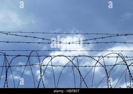 Security area secured with barbed wire fence Stock Photo