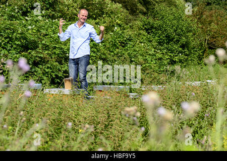 Beekeeper standing on his hives Stock Photo