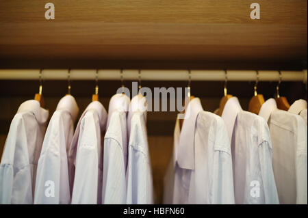 white shirt hanging on a hanger in the closet Stock Photo
