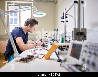 Man soldering in electronics laboratory Stock Photo