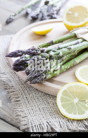 bunch of fresh green asparagus spears on a red table Stock Photo - Alamy