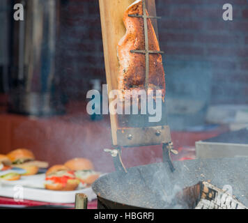 Salmon cooking and smoking on an open fire Stock Photo