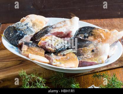 Pieces of carp fish in marinade with oil Stock Photo