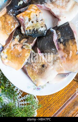 Pieces of carp fish in marinade with oil Stock Photo