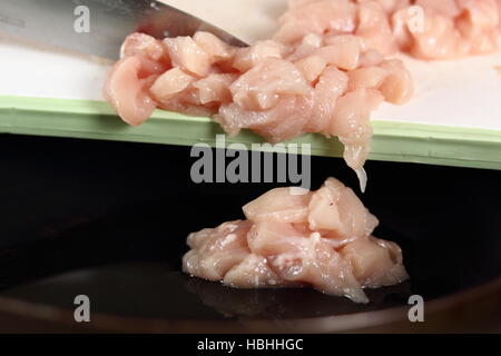 Adding diced chicken fillet into frying pan. Making Chicken and Egg Galette Series. Stock Photo