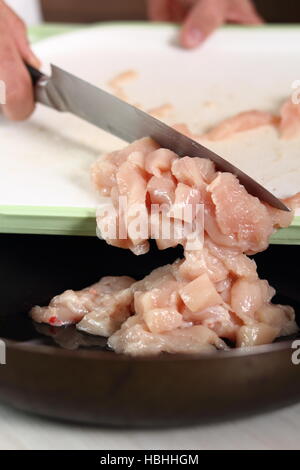 Adding diced chicken fillet into frying pan. Making Chicken and Egg Galette Series. Stock Photo