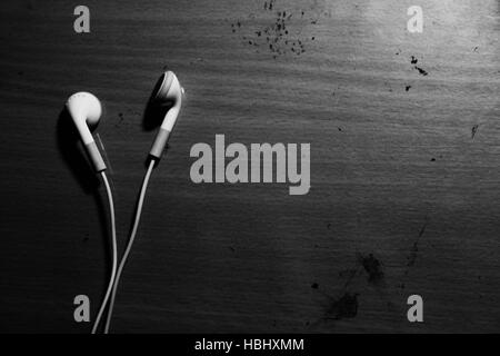 Generic white earbuds on an artist's working table. Stock Photo