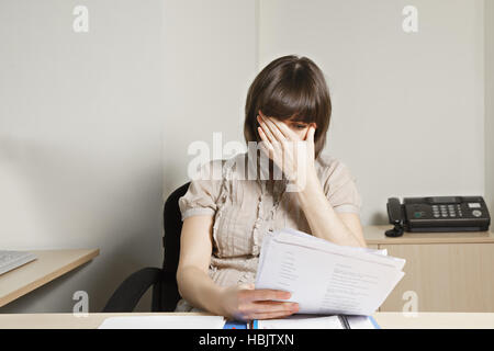 Stressed office worker doing paperwork Stock Photo