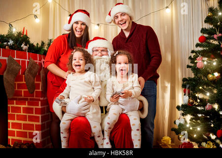 Happy family with Santa Claus laughing and smiling. Stock Photo