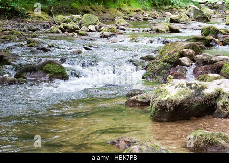 Water stream running over mossy rocks Stock Photo